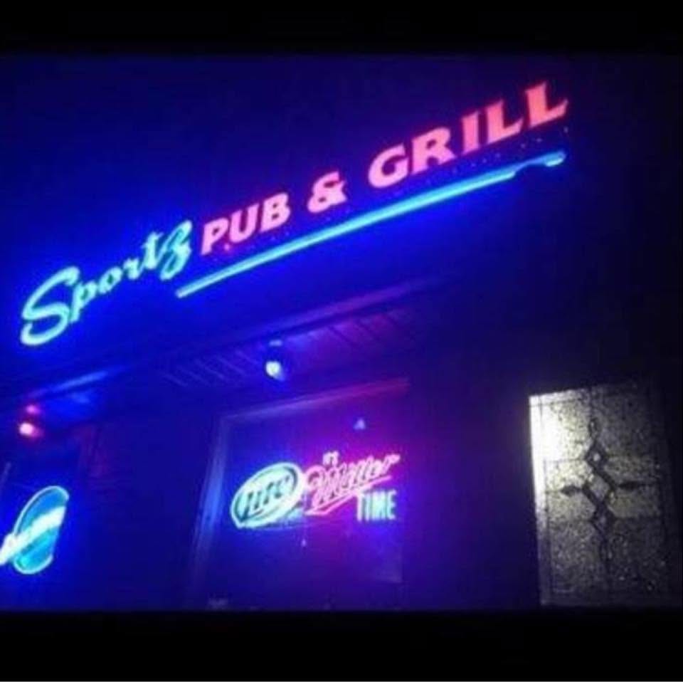 The Sportz Pub & Grill sign glowing in blue neon at night
